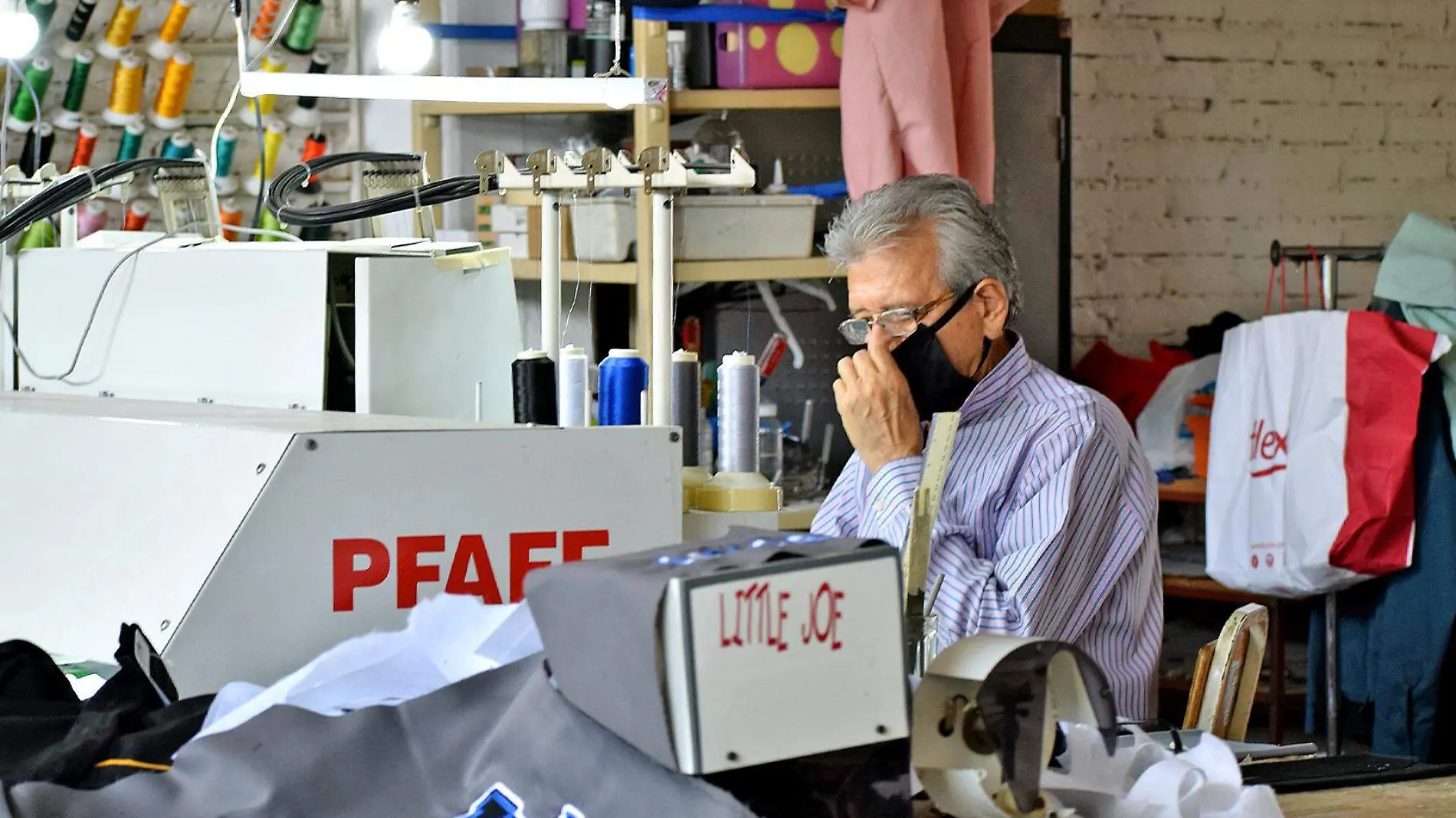 hombre adulto sentado frente a maquina textil